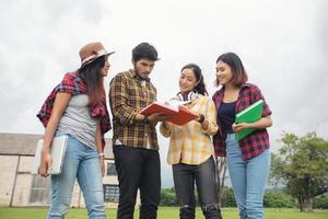 gli studenti del gruppo sorridono e si divertono aiuta anche a condividere idee nel lavoro e nel progetto. e anche rivedere il libro prima dell'esame all'aperto in giardino. foto