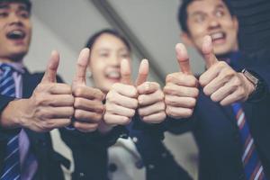 sorridente felice uomo d'affari e imprenditrici che celebrano il successo con il braccio alzato e mostrano il pollice in su concept foto