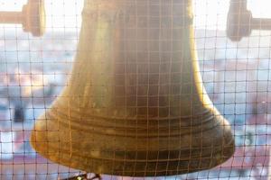 chiudi grande campana di bronzo nella torre della cattedrale foto