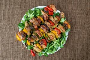 grigliato carne spiedini su un' piatto con verdure foto