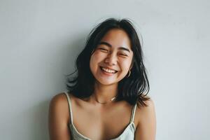 ai generato asiatico donna strizzando l'occhio per telecamera sorridente gioioso in piedi bianca parete foto