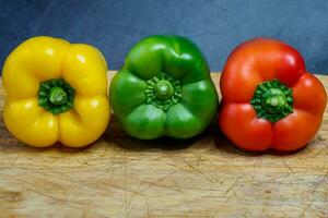 peperoni nel tre colori su un' cucina tagliere foto