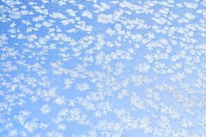 astratto inverno sfondo. brina su un' congelato finestra contro il blu cielo. foto