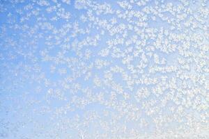 astratto inverno sfondo. brina su un' congelato finestra contro il blu cielo. foto
