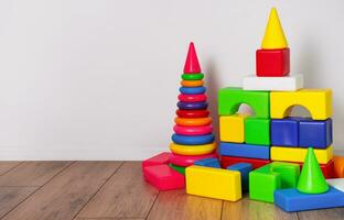 un' impostato di figli di giocattoli nel il figli di camera. figli di progettista e piramide su il pavimento. figli di Giochi. copia spazio. foto