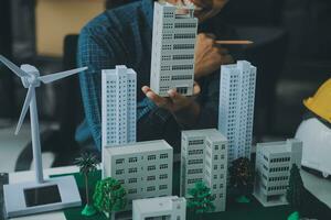 costruzione e struttura concetto di ingegnere o architetto incontro per progetto Lavorando con compagno e ingegneria utensili su modello edificio e planimetria nel Lavorando luogo, contrarre per tutti e due aziende. foto