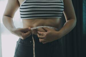 donne corpo Grasso gonfiarsi. obeso donna mano Tenere eccessivo pancia Grasso. dieta stile di vita concetto per ridurre pancia e forma su salutare stomaco muscolo. foto