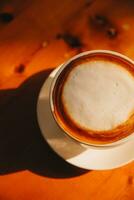 caffè nel bianca tazza su di legno tavolo, con cucchiaio. foto