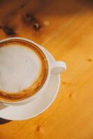 caffè nel bianca tazza su di legno tavolo, con cucchiaio. foto