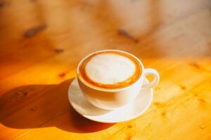 caffè nel bianca tazza su di legno tavolo, con cucchiaio. foto