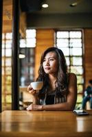 ritratto donna asiatica sorridente rilassarsi nella caffetteria cafe foto