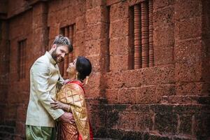 la sposa asiatica e lo sposo caucasico hanno un momento romantico con il vestito thailandese foto