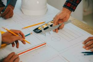 costruzione e struttura concetto di ingegnere o architetto incontro per progetto Lavorando con compagno e ingegneria utensili su modello edificio e planimetria nel Lavorando luogo, contrarre per tutti e due aziende. foto