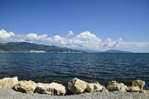 mare baia paesaggio tremendo. montagne e nuvole nel il cielo. nel il distanza può essere visto il marino carico porta foto