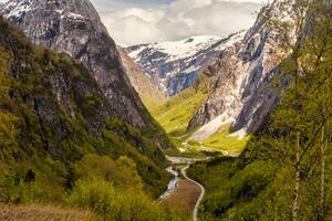 strada in esecuzione attraverso norvegese valle e montagne nel primavera foto