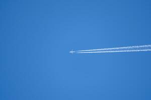 condensazione pista a partire dal un aereo nel un' blu cielo foto