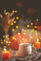 autunno accogliente composizione. tè nel un' tazza, zucche e candele foto