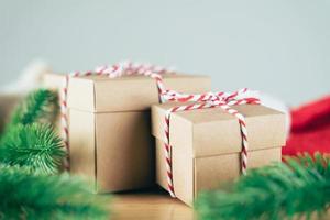 scatola regalo di natale o capodanno con ramo di un albero e decorazioni su tavola di legno.