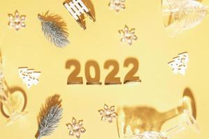 festivo capodanno piatto con numeri 2022 e ombre dure con occhiali e decorazioni lucide foto