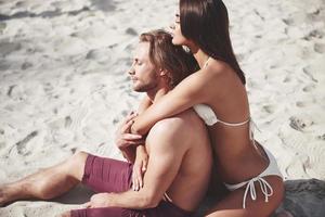una coppia romantica sulla spiaggia in costume da bagno, bei giovani sexy