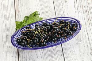 succoso nero ribes frutti di bosco nel il ciotola foto