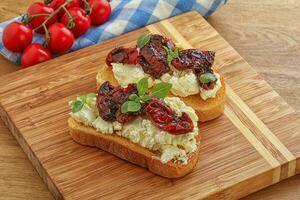 bruschetta con formaggio a pasta molle e pomodoro foto