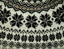 nero e bianca inverno a maglia maglione modello design con fiocchi di neve. fatto a mano maglieria lana tessuto struttura. sfondo di lavorare a maglia modelli e ornamento. foto