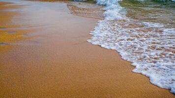 onde Crashing su il bianca sabbia spiaggia foto