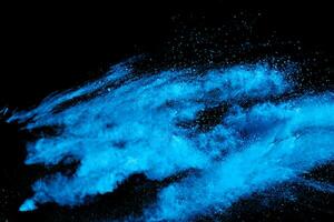 blu polvere esplodere nube su nero sfondo. lanciato blu polvere particelle spruzzo su sfondo. foto