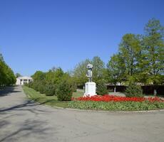 statua di un' collettivo contadino su un' piedistallo. il eredità di il sovietico era. un' fiore letto con tulipani e giovane alberi nel il villaggio di oktyabrsky. krasnodar Krai, Krasnoarmeisky quartiere. foto