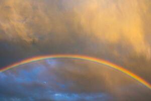 arcobaleno e pioggia nuvole a tramonto. foto