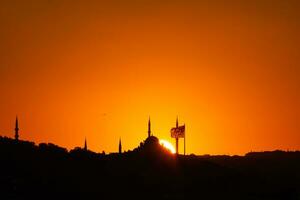 Istanbul silhouette a tramonto. moschea e minareti con bandiera. foto