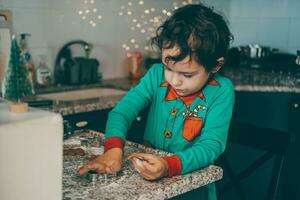 cucina è pieno con risata e gioia ragazzo e mamma con entusiasmo preparare Natale Pan di zenzero foto