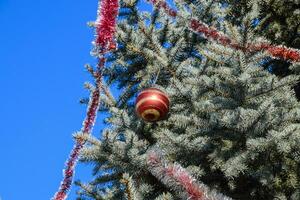 decorazioni nuovo anno albero. orpello e giocattoli, palle e altro decorazioni su il Natale Natale albero in piedi nel il Aperto aria. foto