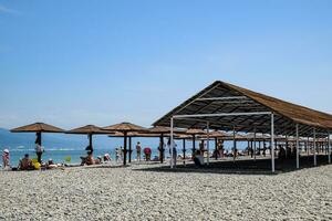 spiaggia tettoie per protezione a partire dal il sole su il spiaggia. ciottolo spiaggia aleksino nel novorossiysk. foto