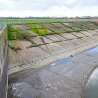 pavimentata calcestruzzo banche di il irrigazione canale a il presa di th foto