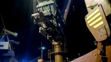 industriale porto di mare a notte. il rotazione di il auto con grano utilizzando un' Torre gru foto