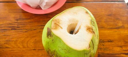 sentire il tropicale freschezza con nostro Immagine di un ghiacciato Noce di cocco su un' di legno tavolo. Perfetto per svegliarsi il tuo sete e desiderio per estate. ottenere esso adesso foto