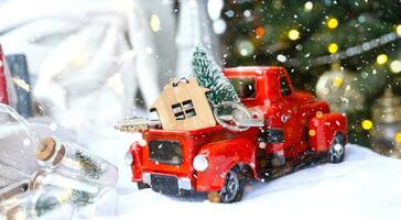 rosso retrò auto con un' Natale albero decora con il Casa chiave nel il Raccogliere camion per Natale. acquisto un' casa, in movimento, mutuo, prestito, vero proprietà, festivo umore, nuovo anno foto