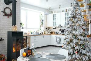 Natale arredamento nel bianca cucina con ardente stufa il camino, festivo disordine, villaggio interno con un' nevoso Natale albero. nuovo anno, Natale umore, accogliente casa. foto