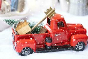 rosso retrò auto con un' Natale albero decora con il Casa chiave nel il Raccogliere camion per Natale. acquisto un' casa, in movimento, mutuo, prestito, vero proprietà, festivo umore, nuovo anno foto