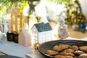 festivo Natale arredamento nel tavolo, fatti in casa torte per colazione, forno biscotti. accogliente casa, Natale albero con Fata luci ghirlande. nuovo anno, Natale umore foto