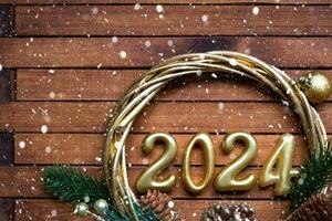 contento nuovo anno di legno numeri 2024 su accogliente festivo Marrone di legno sfondo con paillettes, neve, luci di ghirlande. saluti, cartolina. calendario, copertina foto