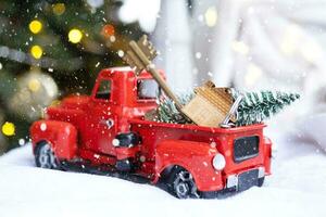 rosso retrò auto con un' Natale albero decora con il Casa chiave nel il Raccogliere camion per Natale. acquisto un' casa, in movimento, mutuo, prestito, vero proprietà, festivo umore, nuovo anno foto