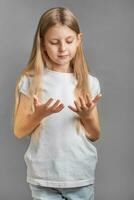 carino poco ragazza guardare a sua mani foto