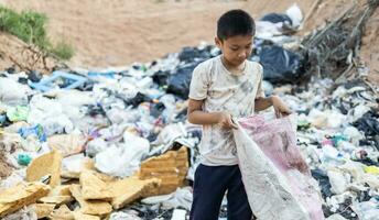 povero bambini su il spazzatura cumulo di rifiuti e Selezione plastica rifiuto per vendere, bambini non nel scuola, povertà. foto