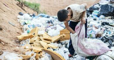 povero bambini su il spazzatura cumulo di rifiuti e Selezione plastica rifiuto per vendere, bambini non nel scuola, povertà. foto