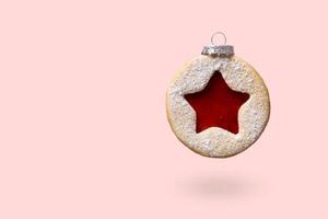 Natale fronzolo fatto di linzer biscotti levitare su rosa sfondo. minimo Natale sfondo foto