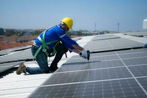 tutti e due di tecnici è installazione solare pannelli su il tetto di il magazzino per modificare solare energia in elettrico energia per uso nel fabbriche. foto