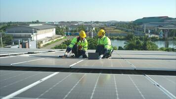 tutti e due di tecnici è installazione solare pannelli su il tetto di il magazzino per modificare solare energia in elettrico energia per uso nel fabbriche. foto
